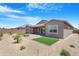 Well-maintained backyard with gravel landscaping, patio area, and artificial turf at 17051 W West Wind Dr, Surprise, AZ 85387