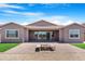 Spacious backyard features an outdoor fire pit with bench seating, desert landscaping, and patio at 17051 W West Wind Dr, Surprise, AZ 85387