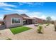 Spacious backyard with patio, artificial turf, desert landscaping and sunny blue skies at 17051 W West Wind Dr, Surprise, AZ 85387