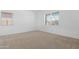 Bright, carpeted bedroom with natural light from two windows at 17051 W West Wind Dr, Surprise, AZ 85387