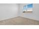 Neutral bedroom featuring tan carpet, white walls, baseboards, and a window with blinds at 17051 W West Wind Dr, Surprise, AZ 85387