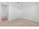 Neutral carpeted bedroom with white walls, baseboards, sliding closet doors and electrical outlets at 17051 W West Wind Dr, Surprise, AZ 85387