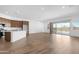 Open-concept living area featuring hardwood floors, a modern kitchen with stainless steel appliances, and sliding glass doors at 17051 W West Wind Dr, Surprise, AZ 85387
