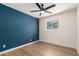 Bedroom features wood-look floors, a ceiling fan, and a modern accent wall at 1959 E Orion St, Tempe, AZ 85283