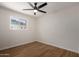 Bright bedroom with wood-look floors, ceiling fan, and a large window at 1959 E Orion St, Tempe, AZ 85283