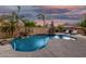 Backyard pool boasts rock waterfall features, lush landscaping, and ample space for outdoor recreation and relaxation at 20211 E Via Del Oro --, Queen Creek, AZ 85142