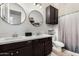 Bathroom featuring a double vanity, white countertop, dark cabinets, and shower with tub at 20211 E Via Del Oro --, Queen Creek, AZ 85142