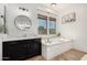 Bright bathroom featuring a garden tub, dark cabinets, and a large window for natural light at 20211 E Via Del Oro --, Queen Creek, AZ 85142
