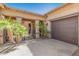 Covered courtyard entry featuring mature palms, decorative wrought iron gate, and a two-car garage at 20211 E Via Del Oro --, Queen Creek, AZ 85142