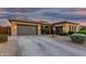 Stunning exterior elevation showcases a three-car garage and desert landscaping at twilight at 20211 E Via Del Oro --, Queen Creek, AZ 85142