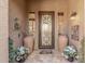 Elegant front entry adorned with decorative pots, flower arrangements, and leaded glass door at 20211 E Via Del Oro --, Queen Creek, AZ 85142