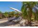 Inviting backyard patio features lounge chairs, decorative rock landscaping, and shade for relaxing outdoors at 20211 E Via Del Oro --, Queen Creek, AZ 85142