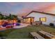 Landscaped backyard with pool, waterfall feature, hot tub, covered patio, and lounge chairs for relaxation and outdoor enjoyment at 2108 E Patrick Ln, Phoenix, AZ 85024