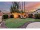 Backyard putting green area with lounge chairs and manicured landscaping at sunset at 2108 E Patrick Ln, Phoenix, AZ 85024