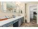 Bright bathroom features a long vanity, sink, mirrors, and doorway to a walk-in closet at 2108 E Patrick Ln, Phoenix, AZ 85024