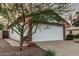 Garage door with stone accents and a well-maintained yard at 2108 E Patrick Ln, Phoenix, AZ 85024