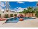 Backyard pool with rock waterfall feature, surrounded by mature landscaping and privacy walls for a tropical oasis at 2108 E Patrick Ln, Phoenix, AZ 85024