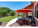 Charming patio with an umbrella-covered dining set, and access to a lush, well-maintained backyard at 2120 N Heritage St, Buckeye, AZ 85396