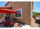 Cozy back patio features a dining set with a red umbrella, creating an inviting outdoor space at 2120 N Heritage St, Buckeye, AZ 85396