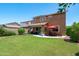 Expansive backyard featuring a covered patio, play area, and lush green lawn at 2120 N Heritage St, Buckeye, AZ 85396