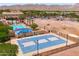 Aerial view of the blue community basketball court, pool, and clubhouse, all surrounded by mountains at 2120 N Heritage St, Buckeye, AZ 85396