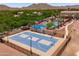 Aerial view of the blue community basketball court, pool, and clubhouse, all surrounded by mountains at 2120 N Heritage St, Buckeye, AZ 85396