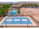 Aerial view of the blue community basketball court, pool, and clubhouse, all surrounded by mountains at 2120 N Heritage St, Buckeye, AZ 85396