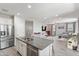 Spacious kitchen with granite island, stainless appliances and tiled floors is open to the living room at 2120 N Heritage St, Buckeye, AZ 85396