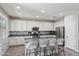 Bright kitchen features an island with bar seating, granite counters and stainless steel appliances at 2120 N Heritage St, Buckeye, AZ 85396