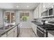 Bright kitchen features granite counters, stainless steel appliances, tile floors and bar seating at 2120 N Heritage St, Buckeye, AZ 85396