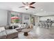 Bright living room with tile floors, large sectional sofa, ceiling fan and kitchen bar seating at 2120 N Heritage St, Buckeye, AZ 85396