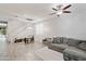 Bright living room with tile floors, a comfortable sectional and open staircase at 2120 N Heritage St, Buckeye, AZ 85396