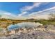 Scenic community pond view with a stone bridge leading to a walking path at 2120 N Heritage St, Buckeye, AZ 85396