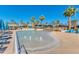 Community pool features clear water, fountains, lounge chairs and is surrounded by lush landscaping and palm trees at 2120 N Heritage St, Buckeye, AZ 85396