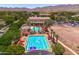 Aerial view of the neighborhood pools with festive decorations, and a nearby clubhouse at 2120 N Heritage St, Buckeye, AZ 85396