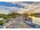 Walking path with stone bridge leading to a lake with trees and distant mountains at 2120 N Heritage St, Buckeye, AZ 85396