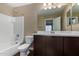 A bathroom features a tub, toilet, and vanity with a large mirror, creating a functional space at 240 W Juniper Ave # 1211, Gilbert, AZ 85233