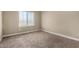 A well-lit bedroom boasts neutral walls and carpet, complemented by a large window that provides natural light at 240 W Juniper Ave # 1211, Gilbert, AZ 85233