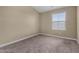 A basic bedroom includes neutral walls and carpet, a window overlooking the roof, and simple trim at 240 W Juniper Ave # 1211, Gilbert, AZ 85233