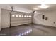 Spacious two-car garage with epoxy flooring, white walls, and electric car charging station at 240 W Juniper Ave # 1211, Gilbert, AZ 85233