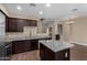 Well-appointed kitchen featuring dark cabinetry, granite countertops, and wood-look tile flooring at 240 W Juniper Ave # 1211, Gilbert, AZ 85233