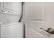 Modern laundry area with a stacked washer and dryer and a white paneled door with lever handle at 240 W Juniper Ave # 1211, Gilbert, AZ 85233