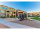Community playground with slides and climbing structures surrounded by sand and grass near well-maintained townhome buildings at 240 W Juniper Ave # 1211, Gilbert, AZ 85233