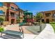Community playground surrounded by townhomes and featuring a slide, climbing structures, and bench seating at 240 W Juniper Ave # 1211, Gilbert, AZ 85233