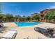 Inviting pool area with lounge chairs, shade trees, and well-kept landscaping throughout the community at 240 W Juniper Ave # 1211, Gilbert, AZ 85233