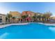 Inviting community pool surrounded by lounge chairs and well-manicured landscaping near multi-story townhome buildings at 240 W Juniper Ave # 1211, Gilbert, AZ 85233