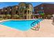 Community pool with bright blue water, pool-side seating, and shade trees near the property's well-maintained buildings at 240 W Juniper Ave # 1211, Gilbert, AZ 85233