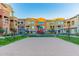 Sand volleyball court with net and playground set surrounded by green grass near multi-story townhome buildings at 240 W Juniper Ave # 1211, Gilbert, AZ 85233