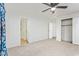 Large carpeted bedroom with a ceiling fan, closet, and entry to the bathroom at 2529 N Barber Dr, Mesa, AZ 85215