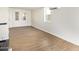Spacious living room area featuring wood-style flooring, white walls and double doors to the exterior at 2529 N Barber Dr, Mesa, AZ 85215